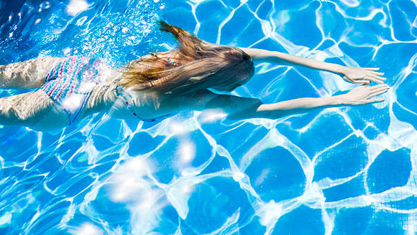 A Woman Swims In Her Personal Swimming Pool.