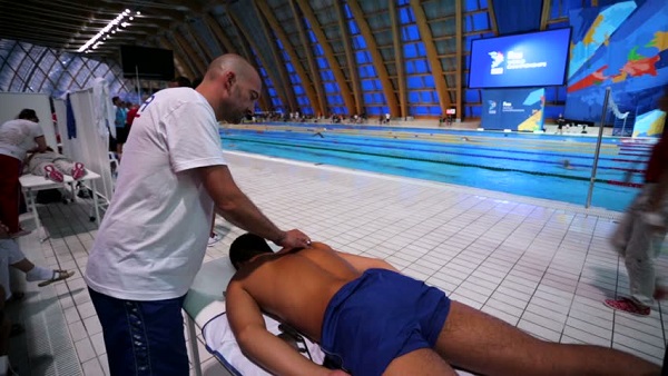 A Swimmer Taken Massage During Swimming From a Massage Therapist.