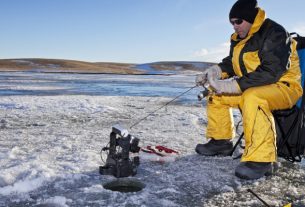 A Man Sitting And Hunting Ice Fish.