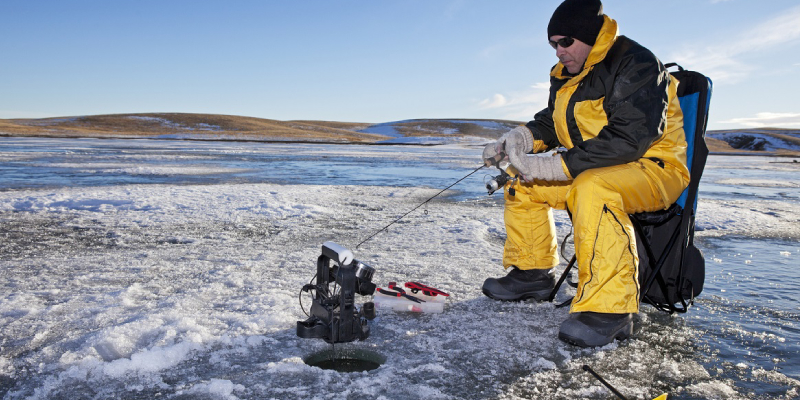A Man Sitting And Hunting Ice Fish.