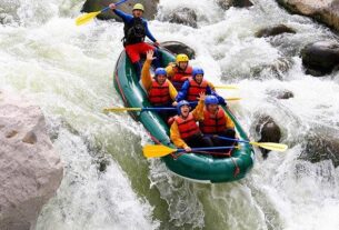 Group of Young People Enjoying While In River Rafting.