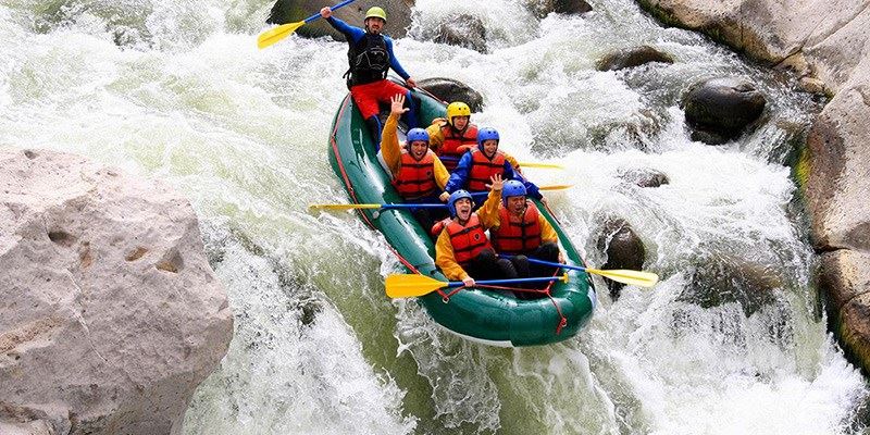 Group of Young People Enjoying While In River Rafting.