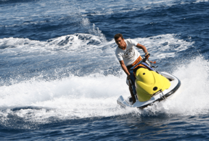 Man Having Fun With Water Scooter In The Beach.