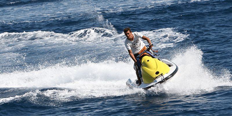 Man Having Fun With Water Scooter In The Beach.