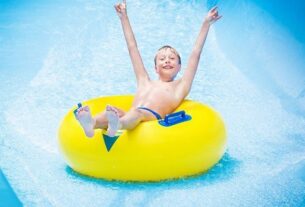 A Small Boy Enjoying Water Slider.