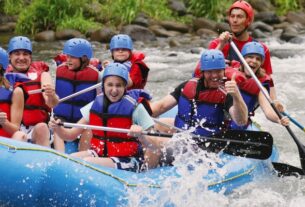 Group of Happy People While In River Rafting.