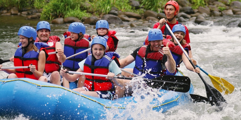 Group of Happy People While In River Rafting.