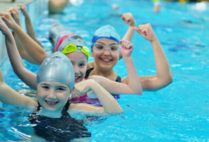 Three Happy Kids Starring At The Camera While Swimming.